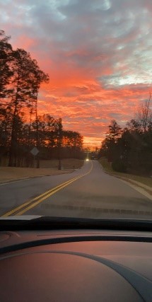 The sunrise is again in the top half of the sky, leaving the rest room for the road and reflections. Photo Credit: Lindsey Walters